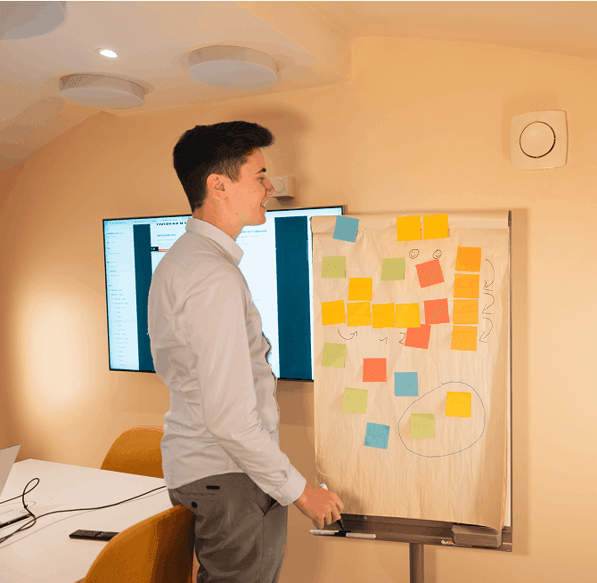 Tableau de gestion de projet de l'agence Najumi à Lyon avec post-its et ordinateur